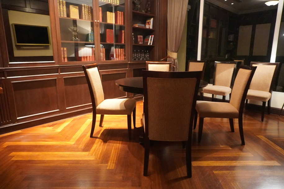 The meeting room: round table, chairs with woven backs, glass-fronted bookcase and wall screen