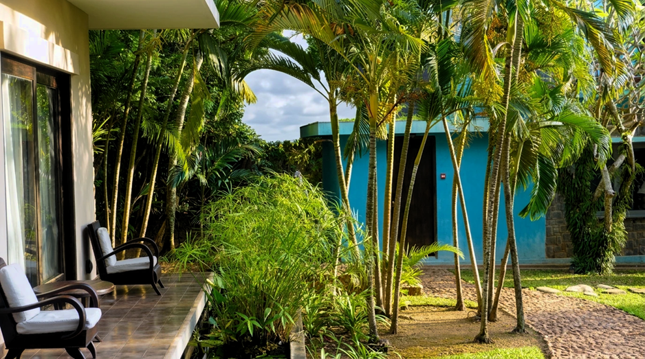 A private terrace framed by towering palms, just steps from the blue villa
