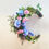 Thumbnail: Floral moon-shaped wreath with blue and pink flowers
