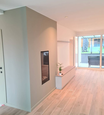 Afgewerkte woonkamer met moluren en plinten in harmonie met schilderwerk