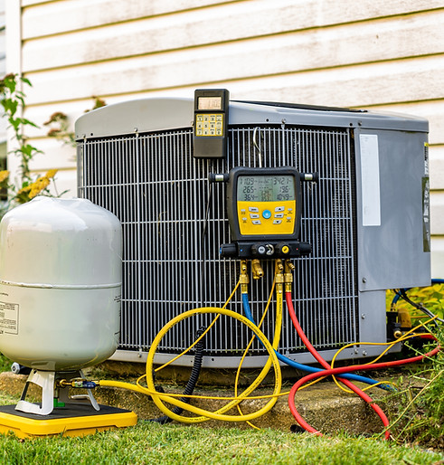 An old air conditioning unit that is being repaired by an HVAC service technician. The tec