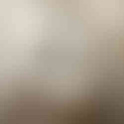 Powder room with wooden vanity and gold fixtures, with wallpaper accent wall