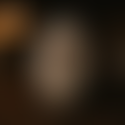 Protection rune Algiz carved on a smooth stone, placed on a wooden table with candlelight in the background