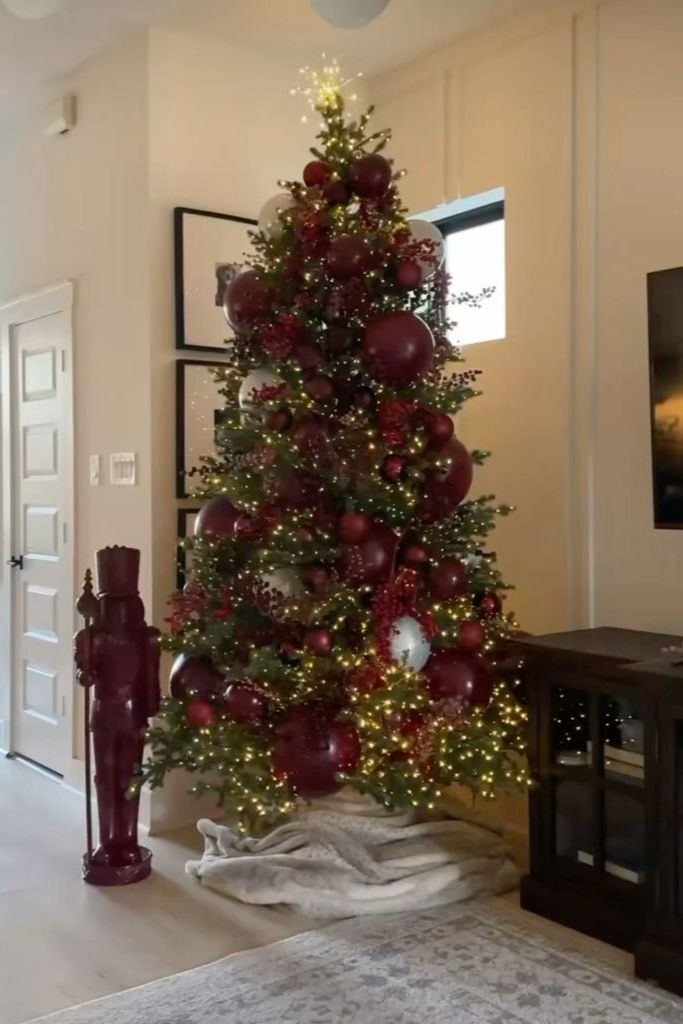 Christmas tree featuring clustered ornament decorations in deep reds and burgundy
