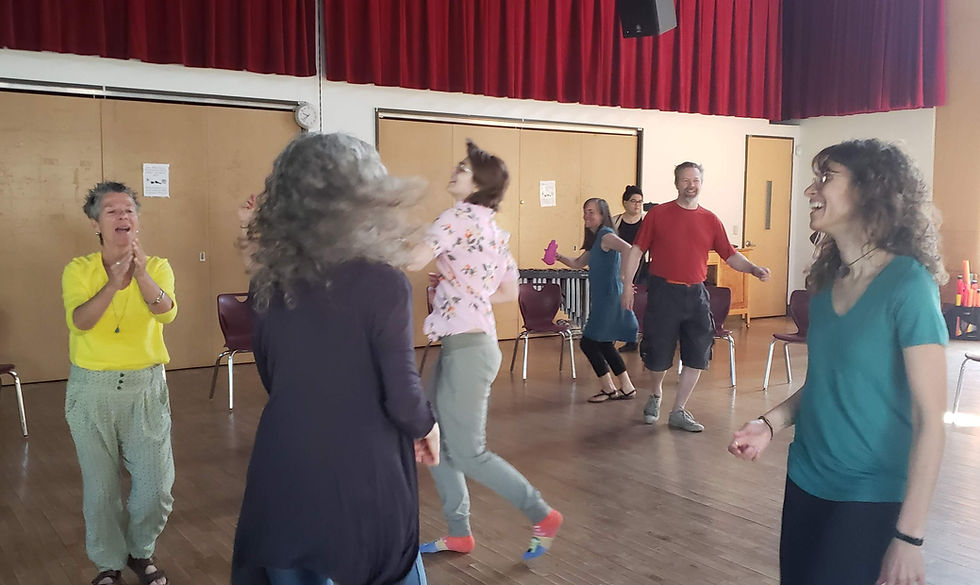 People enjoy dancing in a spacious room with red curtains. They smile and move energetically, creating a joyful and lively atmosphere.
