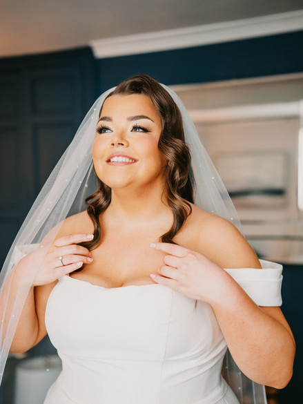 red carpet bridal look, a polished makeup look with neutral tones throughout. This editorial style bride is wearing a satin ball gown dress and hollywood waves
