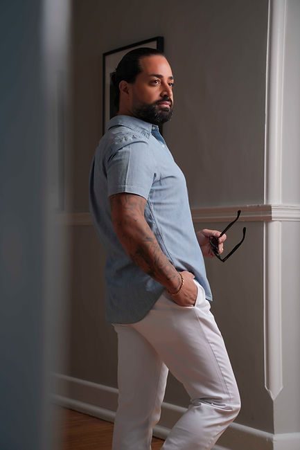 Stylish with glasses poses in white pants.