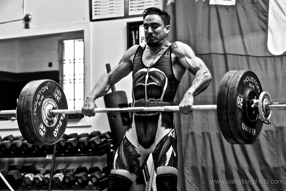 Well muscled man lifting a heavy barbell in Olympic Weightlifting competition