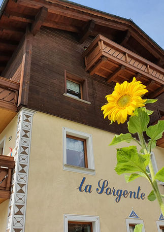 La Sorgente holiday apartments building in the centre of Livigno with traditional Alpine architecture.