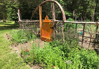A entire garden fence made from cedar branches and cedar logs.