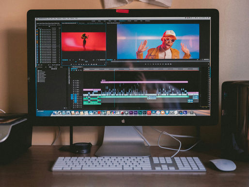 Computer on desk showing video editing software.