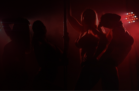 Four people dancing in a nightclub with a dancing pole inbtween them