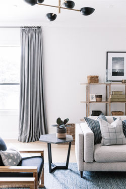 Gray linen curtains, black chandelier, gray sofa, and blue wool rug, living room design by