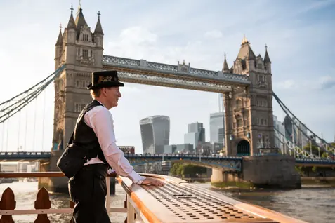 Tour guide on a boat overlooking Tower Bridge during a London corporate event. Professional River Thames event photography and corporate boat cruise coverage by Patryk Majewski at Patryk Creative.