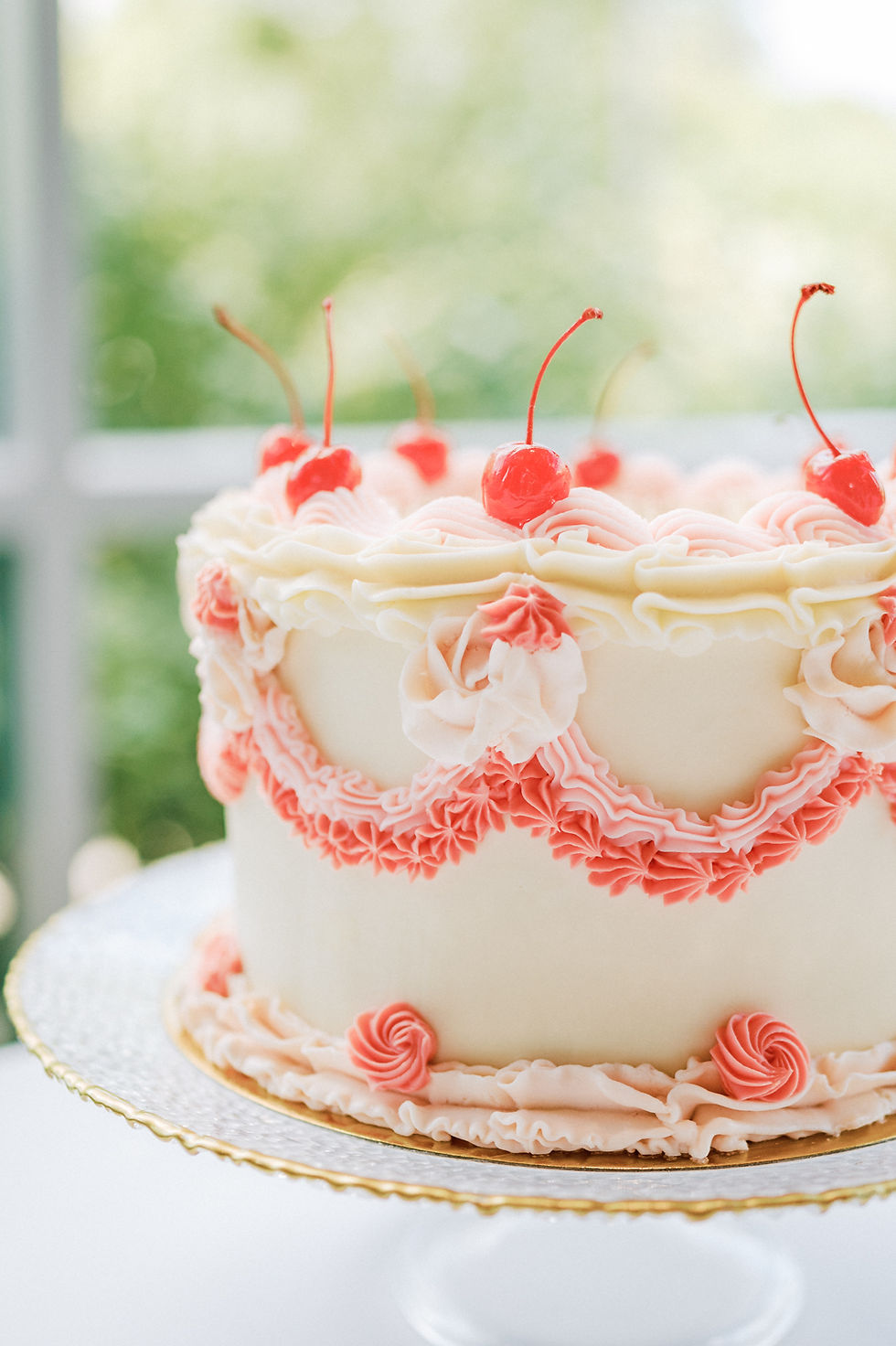 A fun, pink piped wedding cake with cherries on top.
