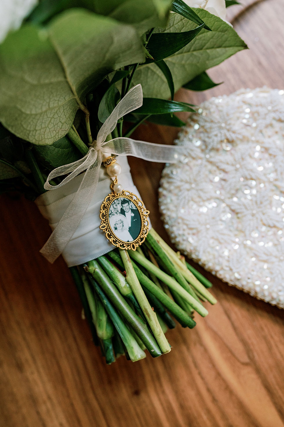 Bridal bouquet featuring a photo of deceased grandparents and a grandmothers vintage beaded wedding clutch