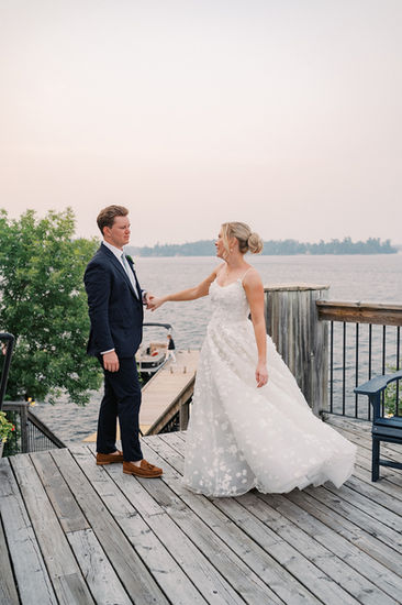 bride and groom snuggle at sunset on the dock of Royal Lake of the Woods Yacht Club