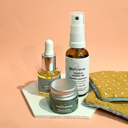 Routine beauté malicieuse. Cela comprend un baume à lèvres à l'huile de noyaux d'abricots bio, un sérum visage naturel et un hydrolat de lavande fine