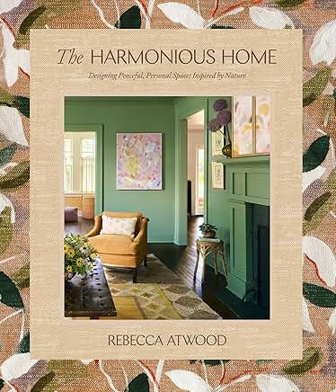 Book cover The Harmonious Home by Rebecca Atwood, showing a cozy green living room with a tan chair, fireplace, and patterned decor.