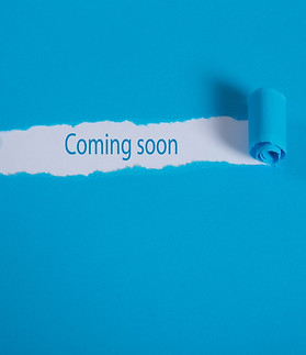 The text COMING SOON behind torn brown paper.jpg