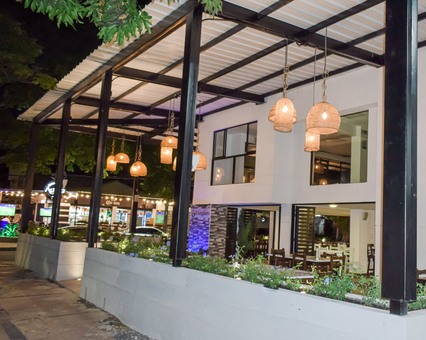 Remodelación Restaurante Manglares , ubicado en frente de acceso vehícular Éxito de la flora, cali valle del cauca.
Remodelación total de fachadas para mayor iluminación y acceso de los clientes, realizada en persiana metálica plegadiza. Barra de atención moderna con iluminación, materas externas con bancas en concreto. Baños y acabados tipo vintage. Cubierta en estructura metálica doble altura en teja UPVC en tubulares de hierro pintados en negro.