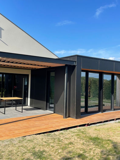 pergola métallique avec ventelles en bois exotique en persiennes pour ombrage et luminosité, terrasse assortie, structure thermolaquée noir mat