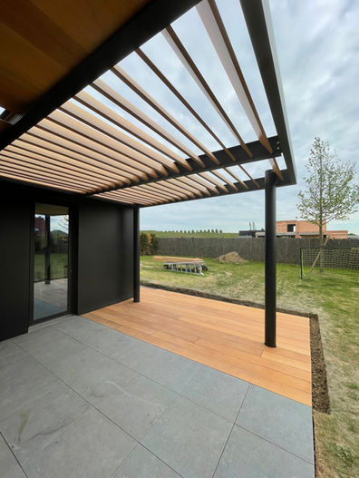 pergola métallique avec ventelles en bois exotique en persiennes pour ombrage et luminosité, terrasse assortie, structure thermolaquée noir mat