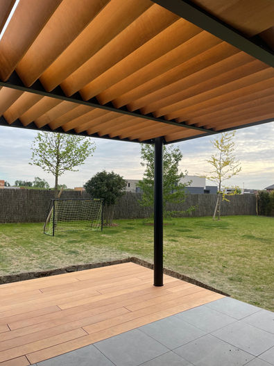 pergola métallique avec ventelles en bois exotique en persiennes pour ombrage et luminosité, terrasse assortie, structure thermolaquée noir mat