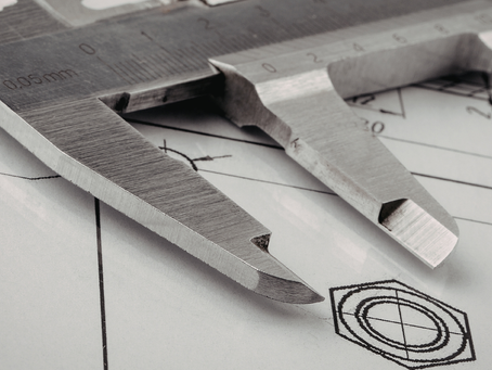Precision caliper measuring technical engineering drawings, symbolizing Six Sigma process analysis and project viability assessment.
