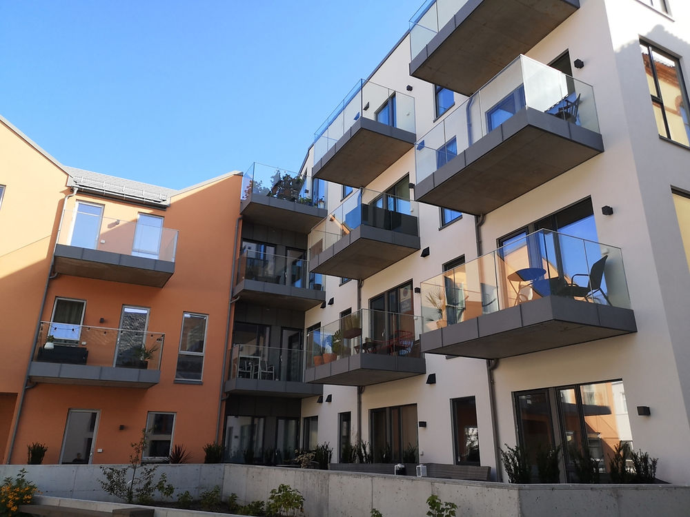 Moderne leilighetsbygg med balkonger med glassrekkverk