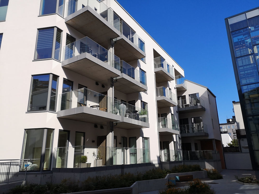 Moderne leilighetsbygg med balkonger med glassrekkverk