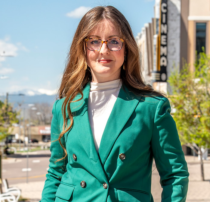 Candidate Claire standing in a relaxed pose in a green suit