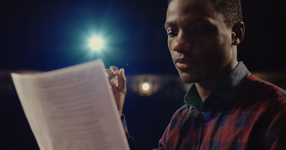 a teenager rehersing a play text in stage light