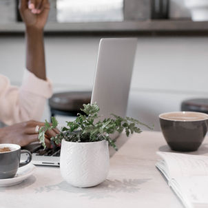 Business meeting with laptops, coffee, and note-taking during a collaborative planning session in a modern workspace.