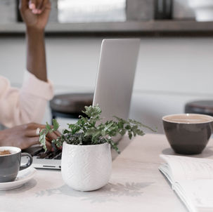 Business meeting with laptops, coffee, and note-taking during a collaborative planning session in a modern workspace.