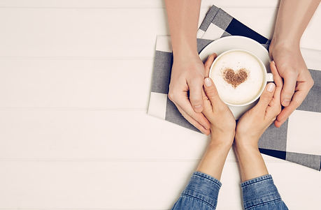 Couple in love holding hands with coffee