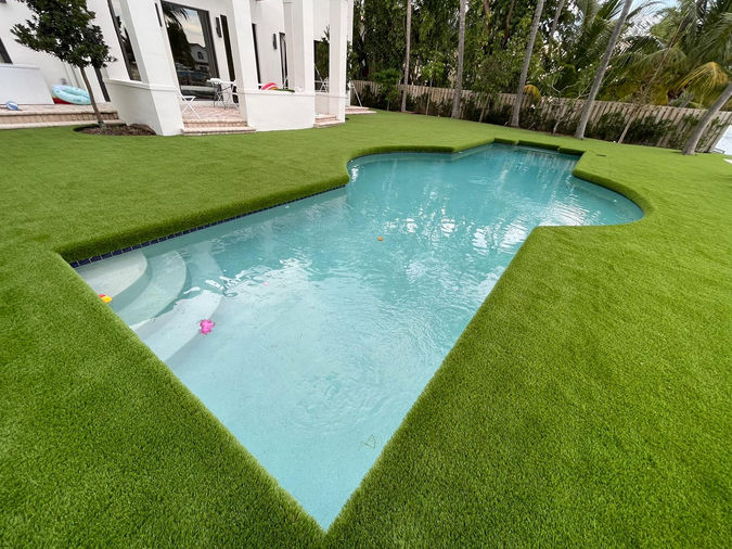 Contemporary backyard pool surrounded by neatly manicured artificial grass, creating a clean, modern look in florida.