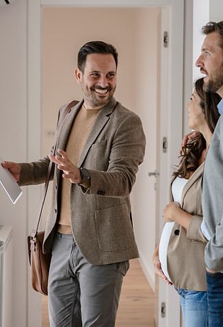 A young couple with a real-estate agent visiting an apartment for sale or for rent Married