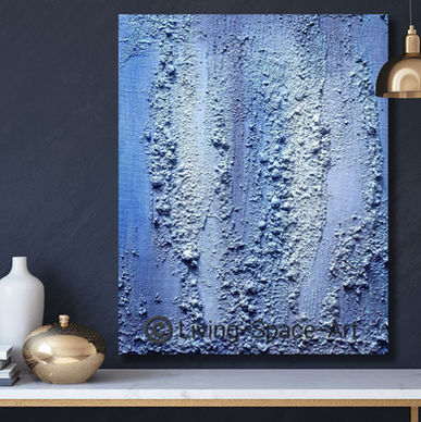 Abstract textured painting on canvas with a coarse-grained texture in various shades of blue on a dark wall