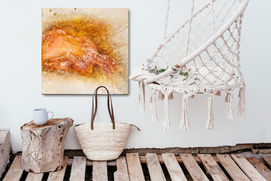 abstract painting with crack forming structure on canvas in yellow and orange shades on a sand colored background
