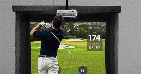 Man playing golf on a simulator, wearing a black shirt and white pants. Screen displays scores and a golf course. Mood is focused.