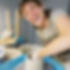 a laughing girl throwing a vessel on the pottery wheel