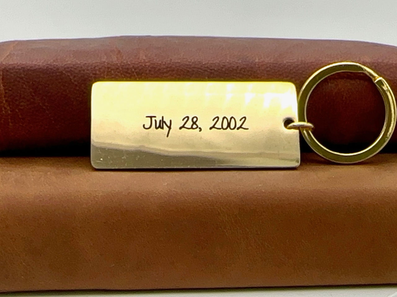 Engraved gold stainless steel keychain with custom coordinates on front and back engraved with wedding date.