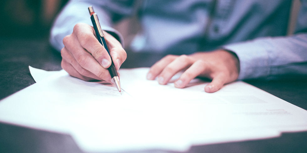 Signing a non- compete agreement with a pen, wearing a blue shirt. The setting is a desk, and the mood is focused.
