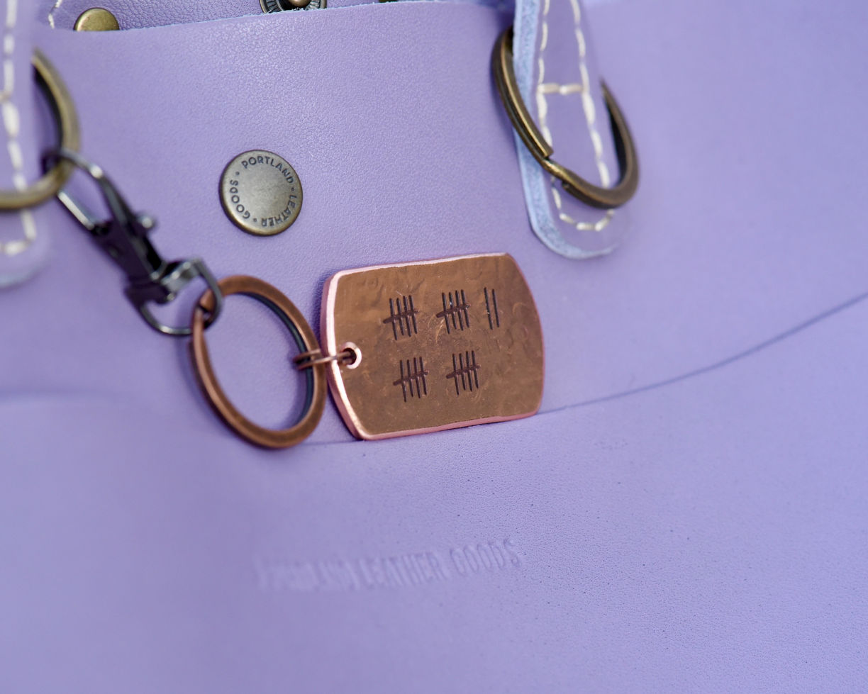 Copper keychain engraved with 22 tally marks and wedding date on the back side."