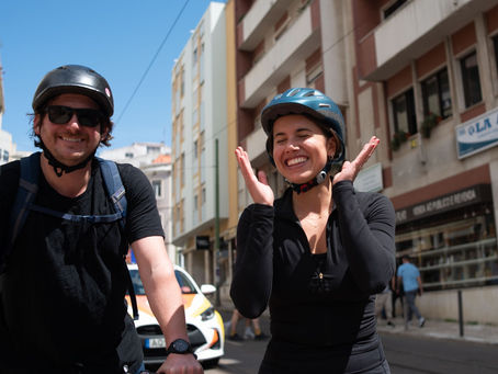 Couple laughing on a private Lisbon bike tour in Estefânia, enjoying scenic streets and a joyful ride together