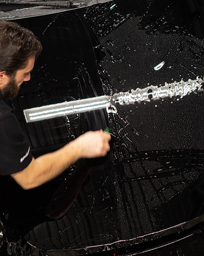 Installer fitting PPF to a bonnet