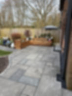 Raised wooden garden planters installed in a Liverpool garden with paved patio and planting beds