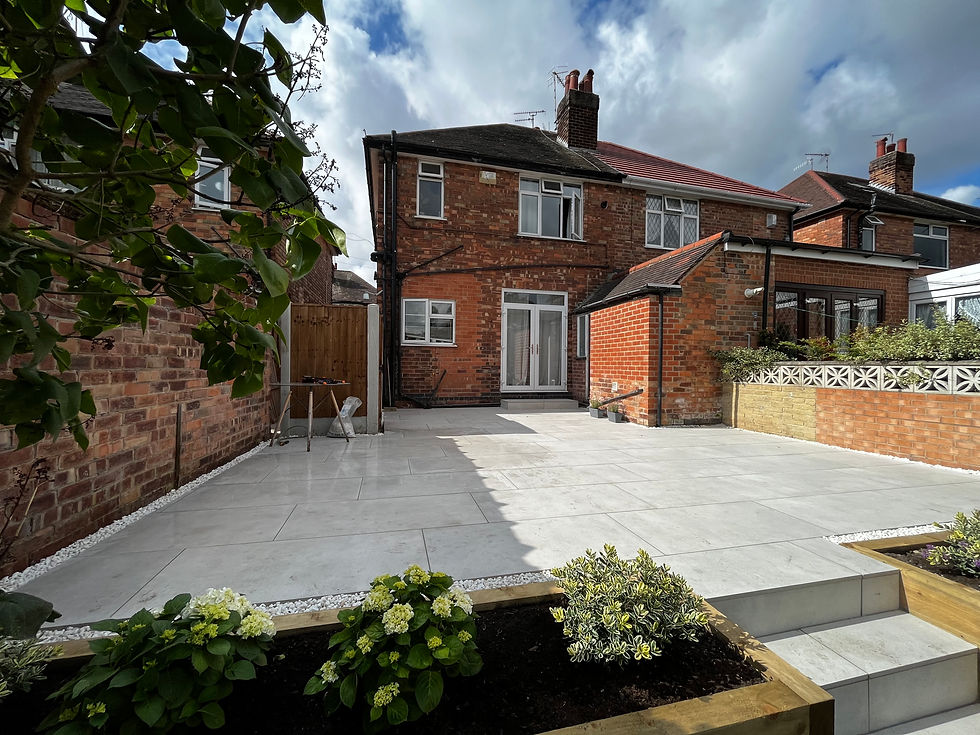 Light grey porcelain patio with raised planters and hydrangeas in a Nottingham garden – patio installation Nottingham