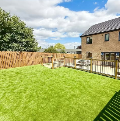 Artificial grass Chesterfield installed in a family garden with timber fencing